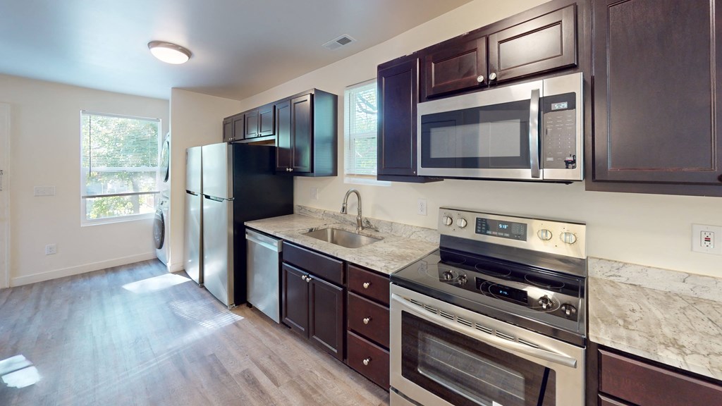 A kitchen with dark brown cabinets and stainless steel appliances.